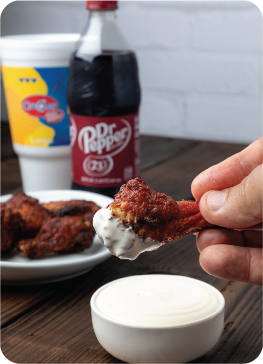 Wings being dipped in ranch.