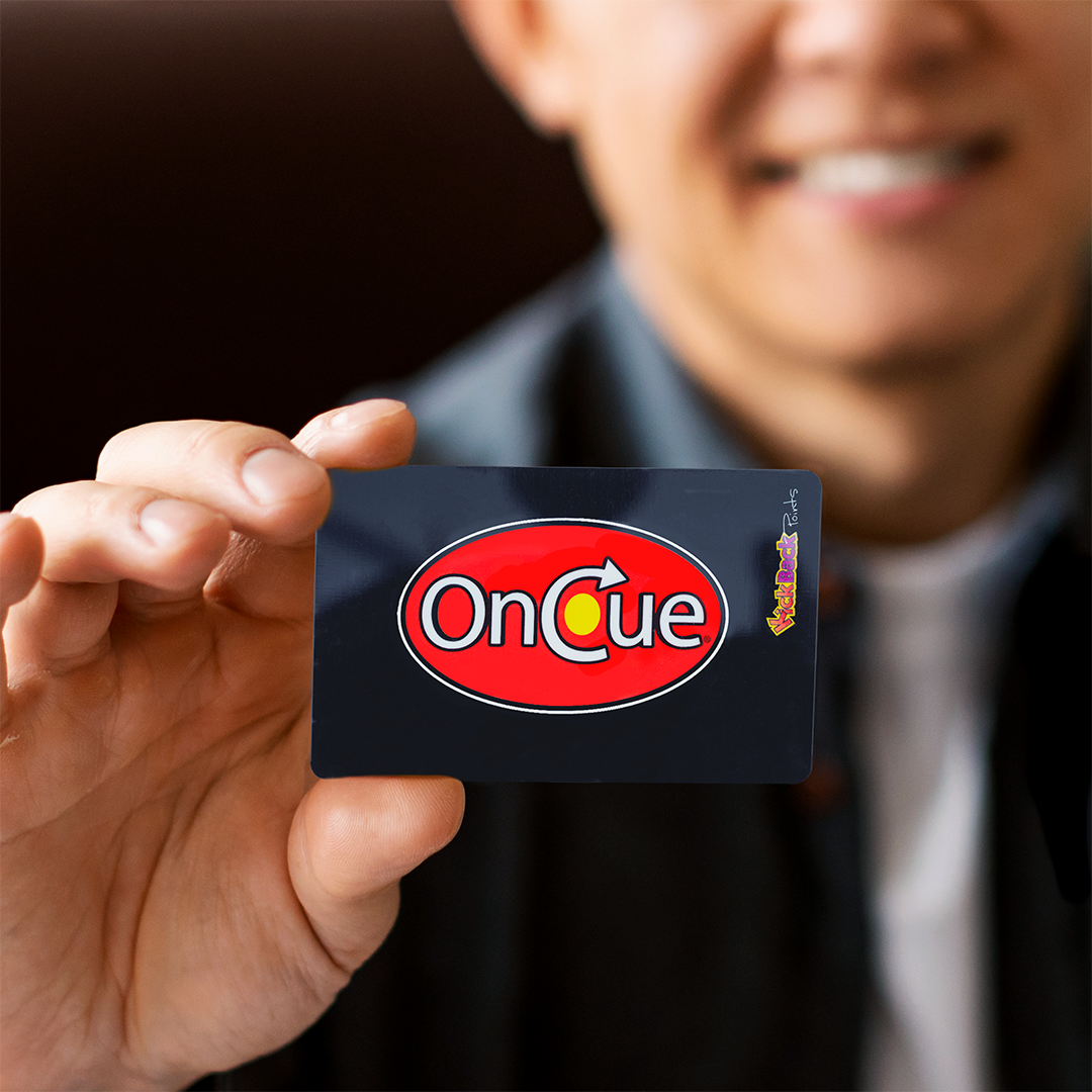 Person holding OnCue Rewards with Kickback Card